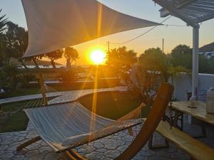a hammock with the sunset in the background at Amorgos Pearls in Katapola