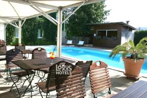 a patio with a table and chairs next to a pool at Logis Hôtel Les Colonnes Strasbourg Zenith in Strasbourg