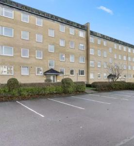 a large building with a parking lot in front of it at Cozy Apartment in Nørresundby