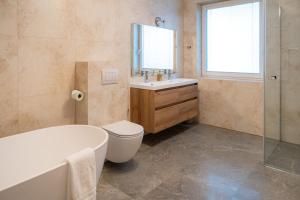 a bathroom with a tub and a toilet and a sink at Penzión Slnečná in Lendak