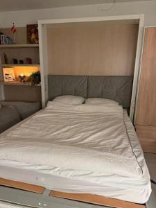 a bed in a room with a large white bedsheet at Cozy Apartment in Nørresundby