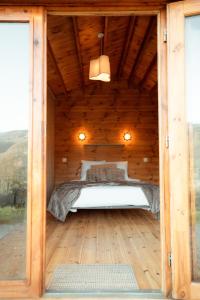 a bedroom in a wooden cabin with a bed in it at Deux Chalets face à la vallée in Chalezeule