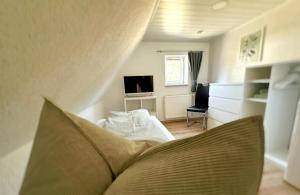 a living room with a couch and a television at Ferienhaus am Erzgebirgskamm in Marienberg