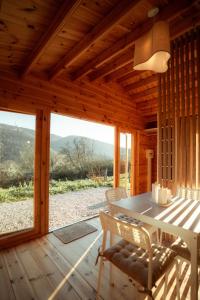 a wooden cabin with a table and chairs on a porch at Deux Chalets face à la vallée in Chalezeule