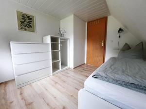 a bedroom with a white bed and a closet at Ferienhaus am Erzgebirgskamm in Marienberg +28 photos