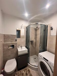 a bathroom with a shower toilet and a sink at Apart Konopnicka in Augustów