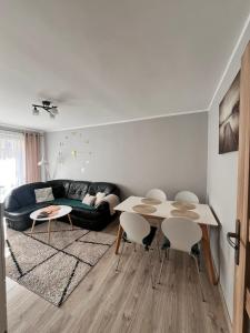 a living room with a table and chairs and a couch at Apart Konopnicka in Augustów