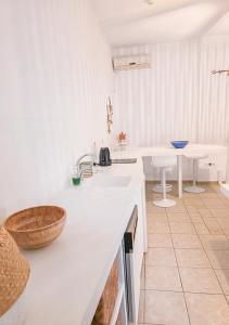 a white kitchen with a sink and a counter at Panostria Apartments Sifnos in Sifnos