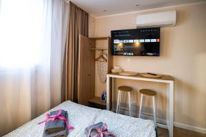 a bedroom with a bed with stools and a tv at Super Central Modern Studio #Palace View #55''Smart TV #Fast Wi-Fi #Metro in Warsaw