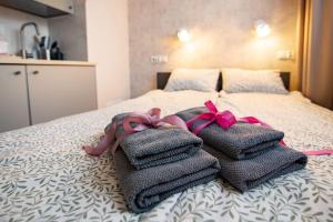 a bed with towels and bows on top of it at Super Central Modern Studio #Palace View #55''Smart TV #Fast Wi-Fi #Metro in Warsaw