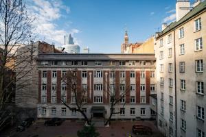 a large brick building in a city with buildings at Super Central Modern Studio #Palace View #55''Smart TV #Fast Wi-Fi #Metro in Warsaw