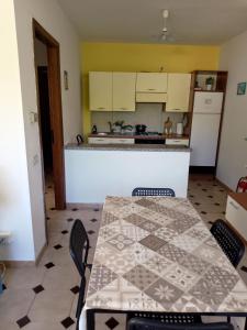 a kitchen with a table and chairs and a counter at Casa vacanze sa minda noa whit a private garden in Olbia