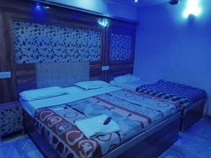 a bedroom with a bed with a table and a phone on it at hotel shree krishna vaishnav in Agra