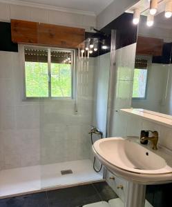 a white bathroom with a sink and a shower at La Mermellina, 22 in Arriondas