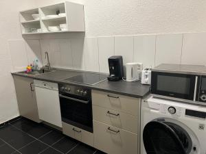 a kitchen with a microwave and a washer and dryer at Monteurswohnung Hamm in Hamm