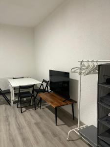 a living room with a table and a television at Monteurswohnung Hamm in Hamm +4 photos