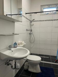 a white bathroom with a toilet and a sink at Monteurswohnung Hamm in Hamm