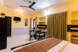 a bedroom with a bed and a chair and a table at Kalyan Villa Heritage Stay in Udaipur