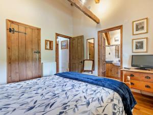 a bedroom with a bed and a flat screen tv at 3 Bed in Winkleigh oc-1450b in Iddesleigh