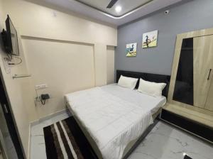 a small bedroom with a bed and a television at Hotel Magic Inn in Nagpur