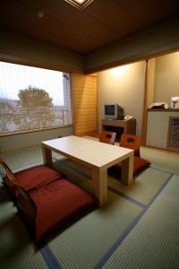 Shiki Resort Prego Hayama في هياما: غرفة مع طاولة وكراسي في غرفة