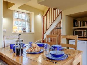 a wooden table with blue dishes and bread on it at 2 Bed in Axminster oc-blolo in Axminster