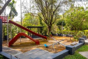 a playground with a red slide in a park at StayVista at Ananta - Breakfast Included & Basketball Court in Bangalore