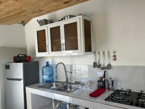 a kitchen with a sink and a refrigerator at Brise Dorée de Punta Rucia in Punta Rucia