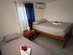 two beds in a small room with flowers on them at Brise Dorée de Punta Rucia in Punta Rucia +15 photos