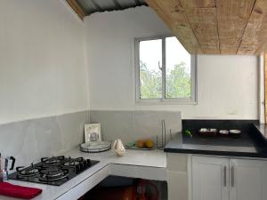 a white kitchen with a stove and a window at Brise Dorée de Punta Rucia in Punta Rucia