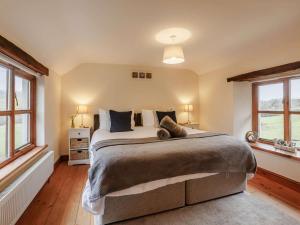 a bedroom with a large bed and two windows at 3 Bed in Barnstaple oc-60511 in Swimbridge