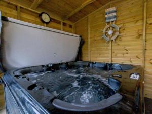 a bath tub in a room with a clock at 3 Bed in Barnstaple oc-60511 in Swimbridge +16 photos