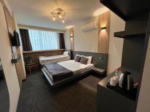 a hotel room with two beds and a television at Hotel ABBARA in İzmir