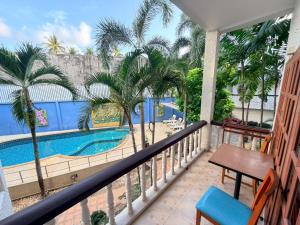 a balcony with a view of a pool and palm trees at Blue Neptuna Hotel Patong in Patong Beach