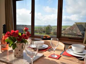 a table with glasses and a vase with flowers on it at 4 Bed in Tiverton oc-60110 in Uplowman +20 photos