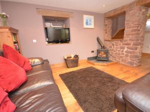 a living room with a leather couch and a fireplace at 2 Bed in Minehead oc-41218 in Timberscombe