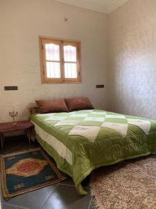 a bedroom with a large bed and a window at Chez houssam in Ouarzazate