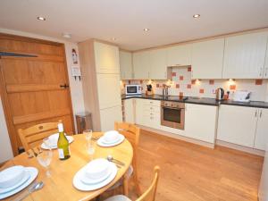 a kitchen with a wooden table with chairs and a dining room at 2 Bed in Minehead oc-41218 in Timberscombe +5 photos