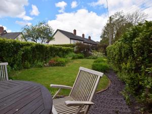 two white chairs and a table in a yard at 2 Bed in Minehead oc-41218 in Timberscombe