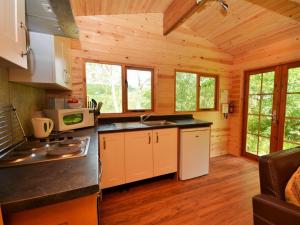 a kitchen in a log cabin with wooden walls at 1 Bed in Tiverton oc-wonlo in Bampton +3 photos