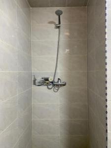 a shower with a shower head in a bathroom at Chez houssam in Ouarzazate