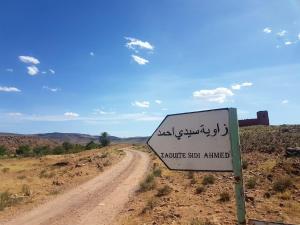 a sign in the middle of a dirt road at Chez houssam in Ouarzazate +12 photos