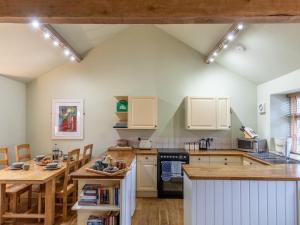 a kitchen with white cabinets and a wooden table at 2 Bed in Axminster oc-bloom in Axminster +12 photos