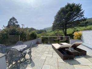 a patio with a table and chairs and a view of a field at 1 Bed in Bridport oc-94617 in Chideock