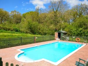 a swimming pool in a yard with a fence at 2 Bed in Chulmleigh oc-87668 in Chulmleigh