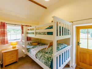 a bedroom with two bunk beds and a desk at 2 Bed in Chulmleigh oc-87668 in Chulmleigh +12 photos
