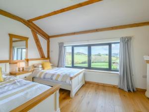 a bedroom with two beds and a large window at 5 Bed in Tiverton oc-48151 in Cadeleigh