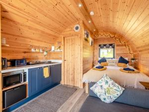 a log cabin bedroom with a bed and a kitchen at 1 Bed in Barnstaple oc-90190 in Bratton Fleming