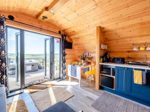 a kitchen with blue cabinets and a large window at 1 Bed in Barnstaple oc-90190 in Bratton Fleming
