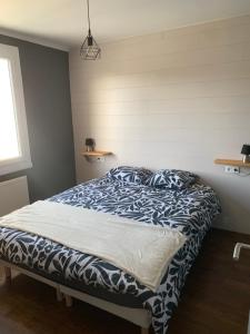 a bedroom with a bed with a blue and white comforter at gîte Théalys- proche Puy du Fou in La Petite-Boissière